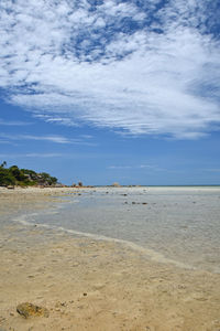 Scenic view of beach against cloudy sky