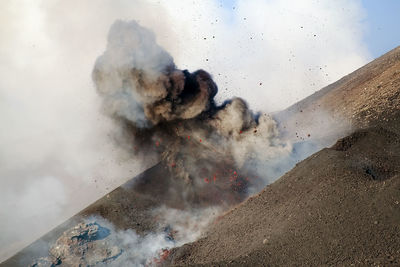 Volcano exploding against sky