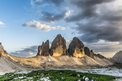 Low angle view of tre cime di lavaredo against cloudy sky during winter