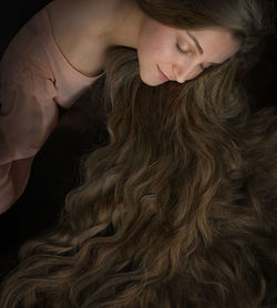High angle view of woman lying down against black background