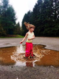 Girl jumping in mud puddles 