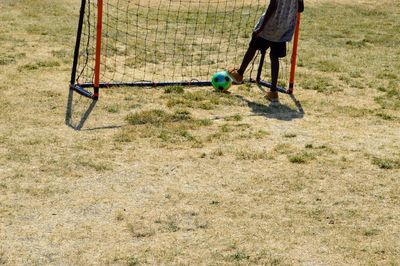 Low section of man playing soccer on sports field