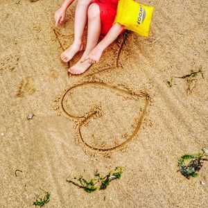 High angle view of child playing on sand at beach
