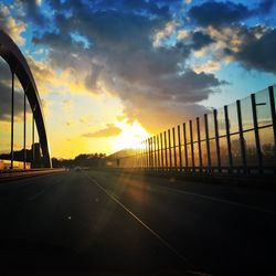 Road in city against sky during sunset