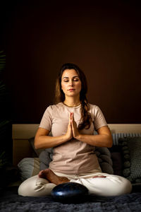 Beautiful woman meditating at home