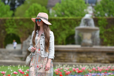 Smiling woman wearing sunglasses walking in park