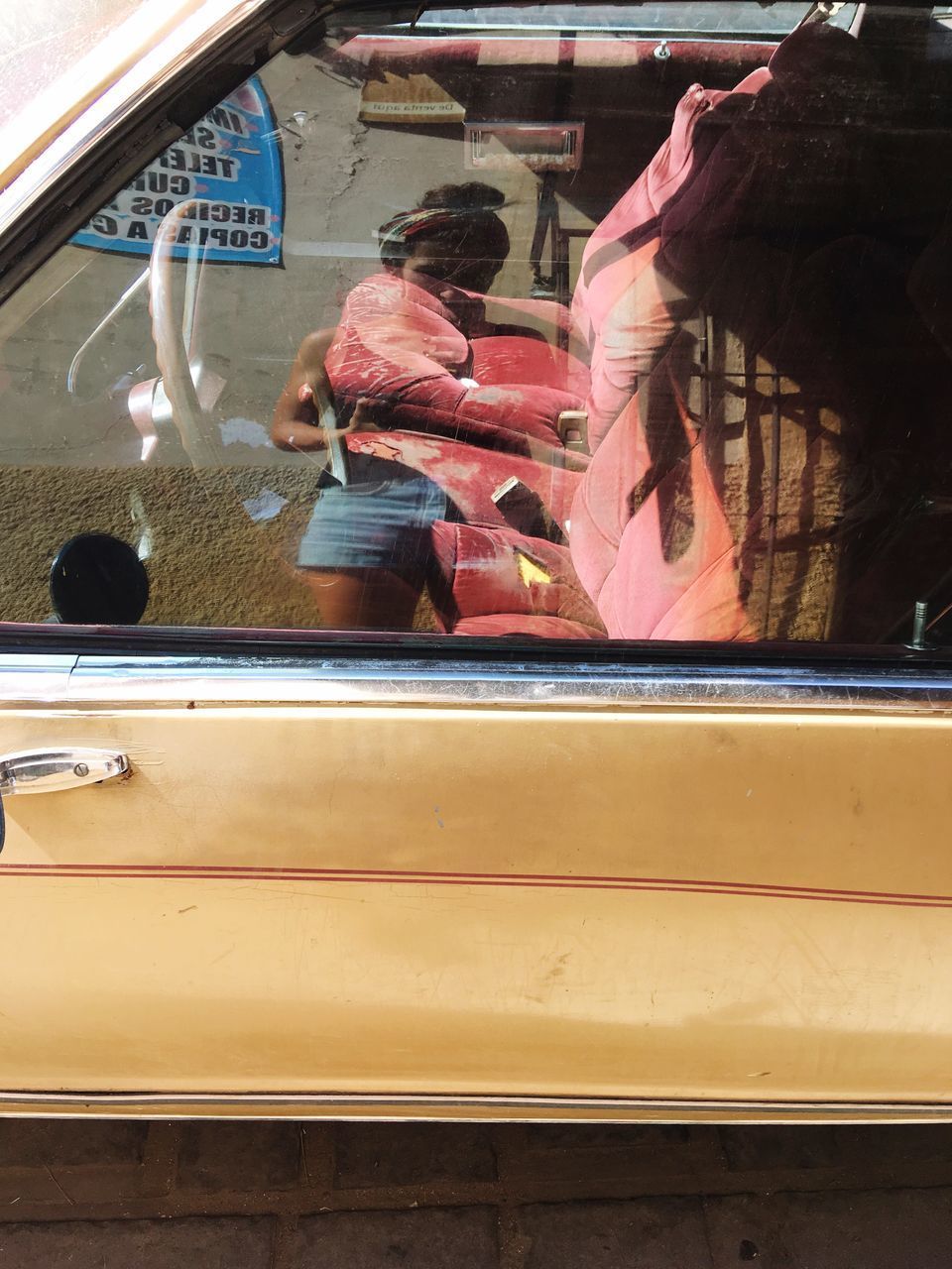 REFLECTION OF PEOPLE IN CAR WINDOW