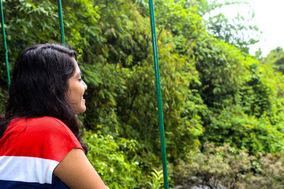 Smiling woman by trees in forest