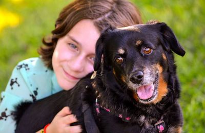 Portrait of smiling girl with dog at park