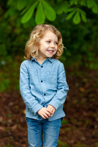 Cute smiling girl looking away while standing outdoors