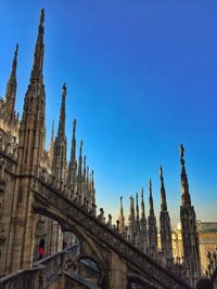 Low angle view of duomo di milano against clear blue sky in city