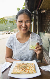 Woman enjoying a drink and a snack at the tropical island ilha grande