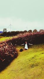 Rear view of woman on field against sky
