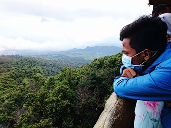 Couple kissing on mountain against sky