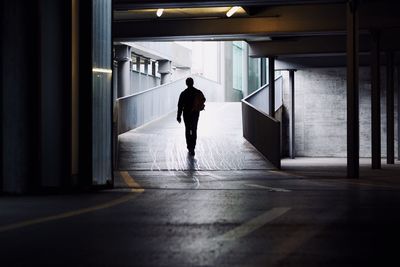 Rear view of man walking in basement