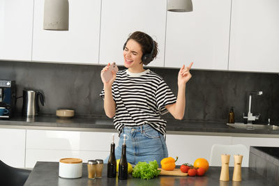 Portrait of smiling young woman standing at home