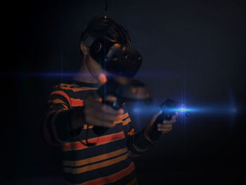 Man photographing illuminated lamp at night