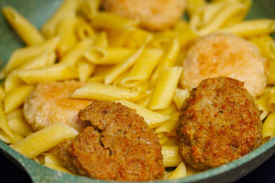 Pasta with meatballs in skillet, close-up