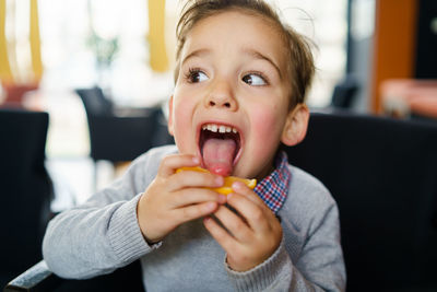 Close-up of boy licking lemon at home