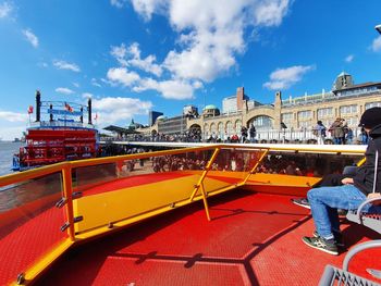 People on boat in city against sky