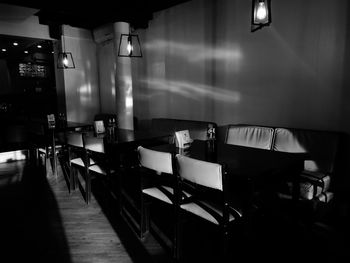 Empty chairs and table in illuminated room
