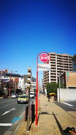 Road sign against clear blue sky