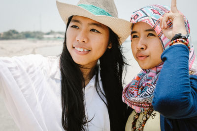 Young woman with friend looking away