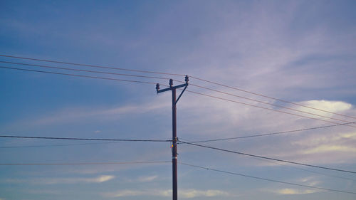 Low angle view of electricity pylon against sky