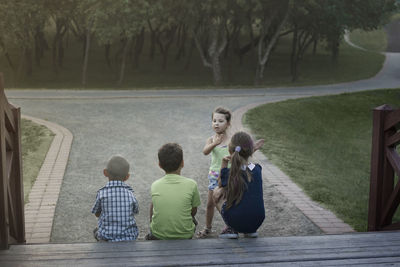 Children play in nature at sunset the girl explains the rules of the g