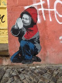 Close-up of person standing against brick wall