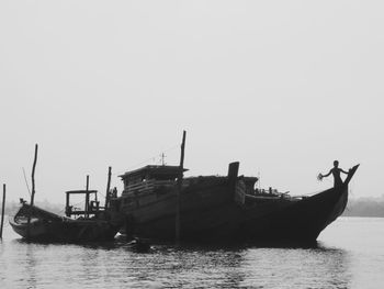 Boats in sea against clear sky