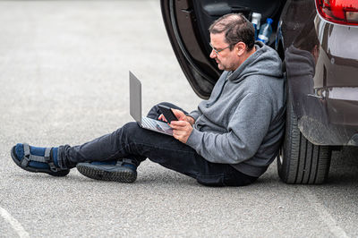 Low section of man sitting on road