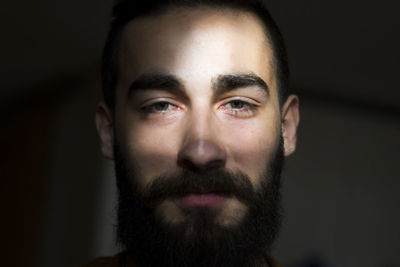 Close-up portrait of young man against black background