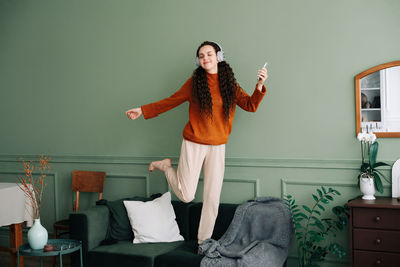 Joyful young woman dancing to her favorite music at home. happy girl experiencing joy while