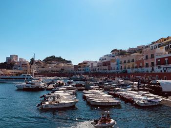 Boats moored in harbor by buildings in city