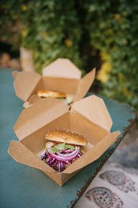 Freshly prepared burgers in take away boxes on table at restaurant