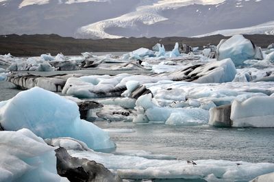 Scenic view of frozen river against snowcapped mountains