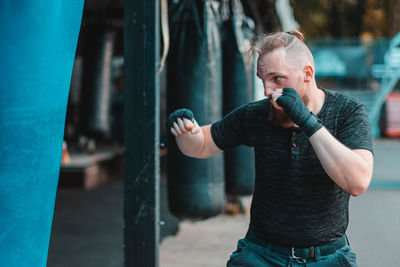 Young man practicing boxing while standing outdoors