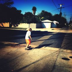 Rear view of a man walking on road