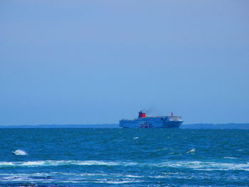 Ship sailing on sea against clear sky