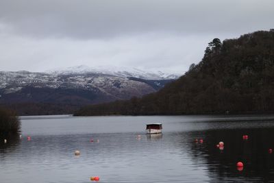 Scenic view of lake by mountains against sky