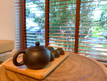 Tea cup on table by window at home