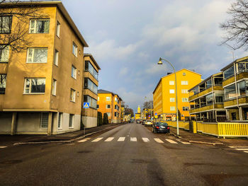 Street amidst buildings against sky in city