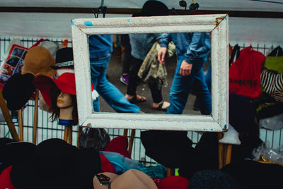 Close-up of hats for sale with reflection of people