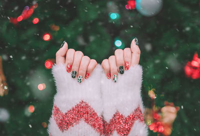 Cropped hand of woman holding christmas tree