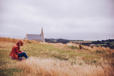 Side view of woman resting in grassy field