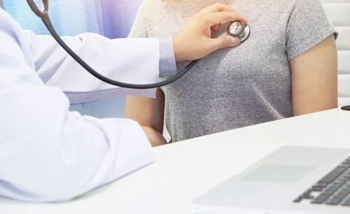 Midsection of man using laptop on table