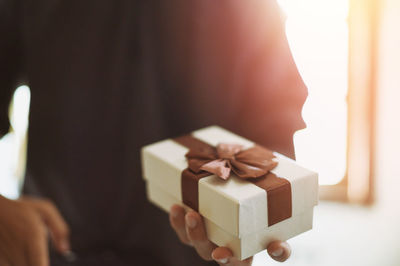 Close-up of woman holding camera in box