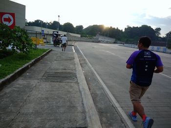 Rear view of man on road against sky