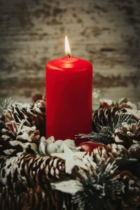 Close-up of candle with pine cone on table